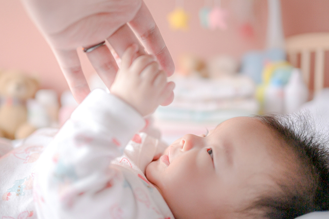 大人の指を握る赤ちゃんの小さな手