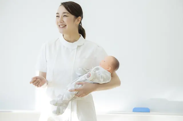 赤ちゃんを抱いて育児支援について説明する女性講師