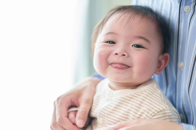 保護者に抱かれて安心した表情を見せる赤ちゃん